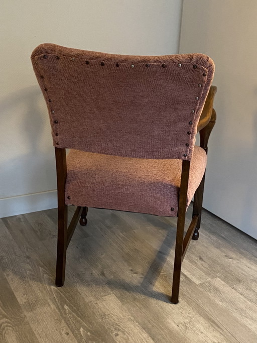 Magnifique fauteuil vintage avec une structure en bois robuste et des accoudoirs élégants.