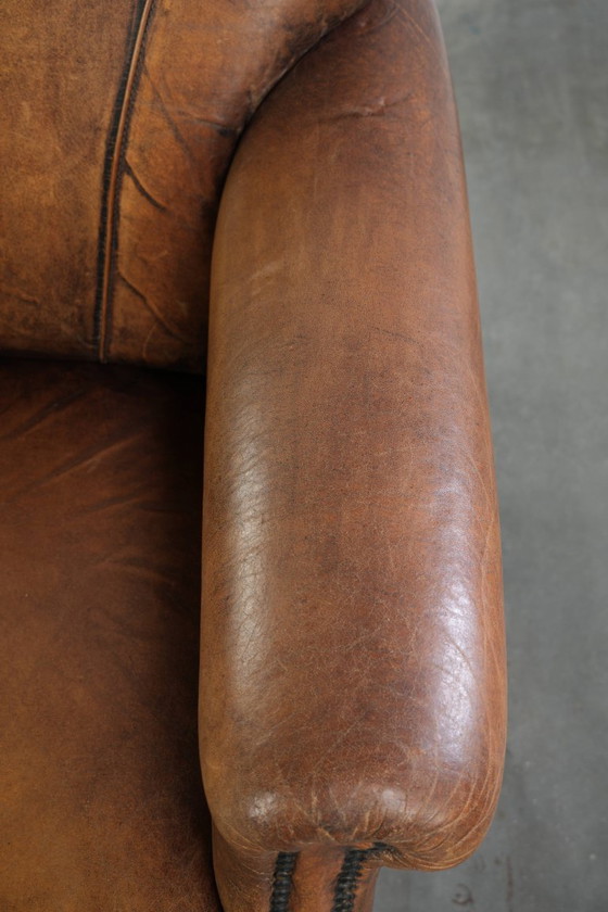 Comoda poltrona in pelle di pecora, dal carattere deciso, rifinita con borchie decorative e una splendida (photo 8 of 13)