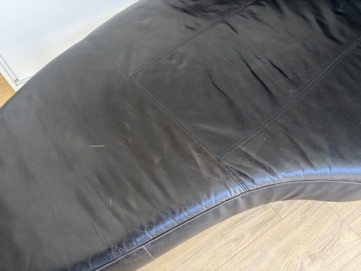 Divano Cheselong, design nero, rivestimento in pelle, gambe in acciaio.