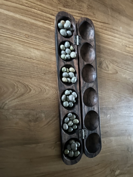 Image 1 of Een vintage houten Mancala-spel, uit hout gesneden. Een soort zaden dienen als