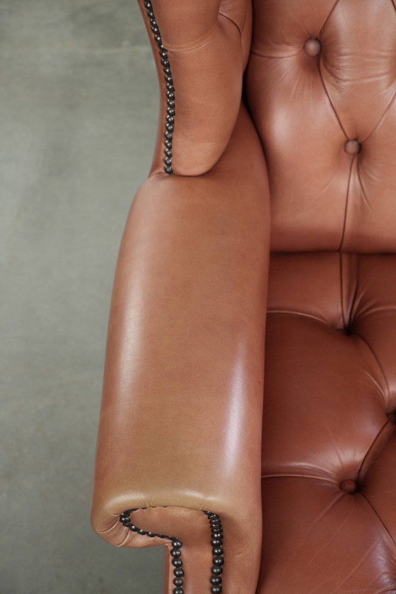 Image 1 of Fauteuil Chesterfield à oreilles en cuir de vachette anglais, assise capitonnée, avec une belle patine et de jolies couleurs.