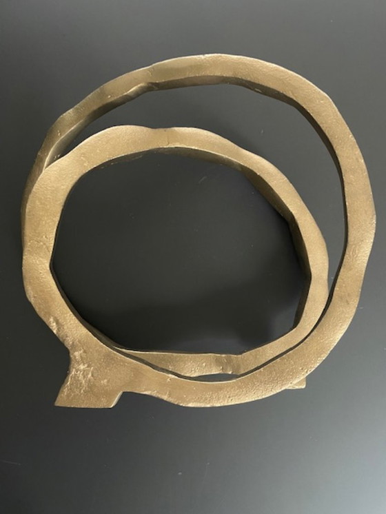 Image 1 of Escultura de diseño con forma de anillo abierto en oro mate.