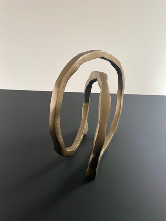 Image 1 of Escultura de diseño con forma de anillo abierto en oro mate.