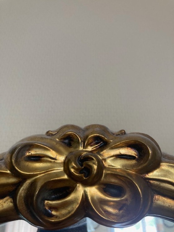 Image 1 of Espejo ovalado decorativo de estilo Luis XVI, de época, con cristal facetado y peineta ornamentada en forma de lazo.