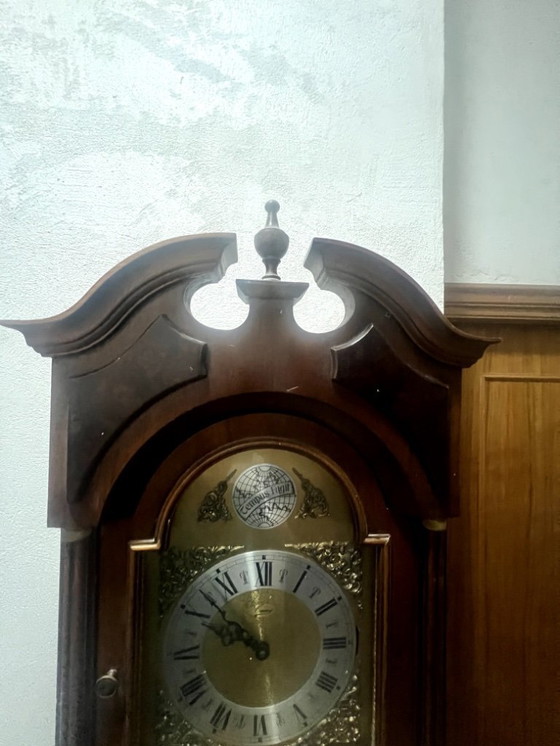 Image 1 of Eine hölzerne Pendeluhr mit einem Schweizer mechanischen Uhrwerk