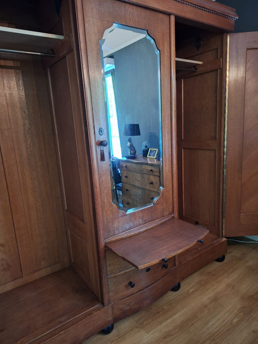 Armoire ancienne avec 2 sections suspendues et une étagère centrale.