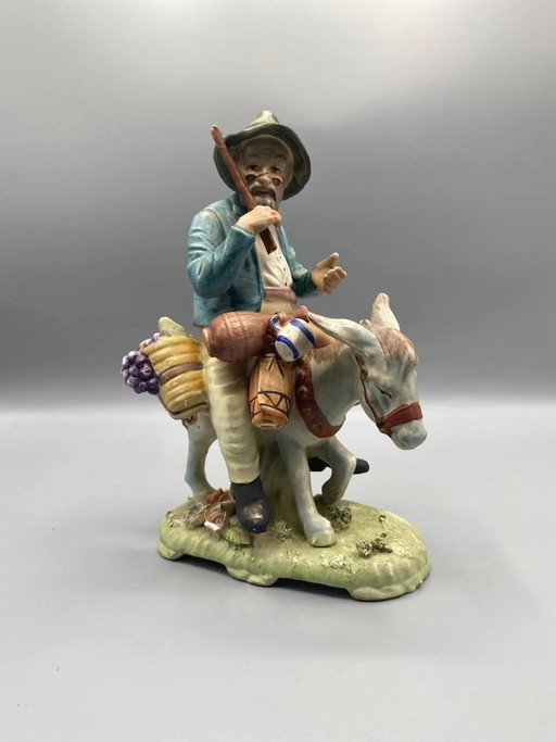 Figurative bisque group, peasant and his donkey loaded with fruit, polychrome, Mediterranean style – beeldhouwkunst