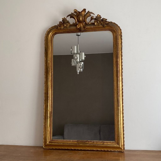 Vergulde spiegel uit de late 19e eeuw met gedecoreerd fronton. 130x74 cm.