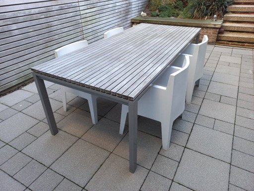 Mesa de comedor moderna para jardín con estructura de aluminio y madera de teca.
