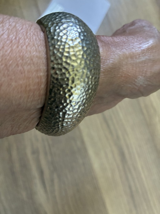 Bracciale in metallo martellato con chiusura a scatto.