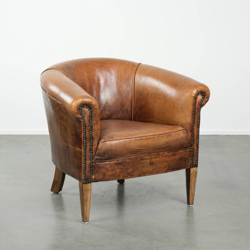 Sillón club vintage de piel de oveja en un tamaño discreto con hermosos colores cálidos.