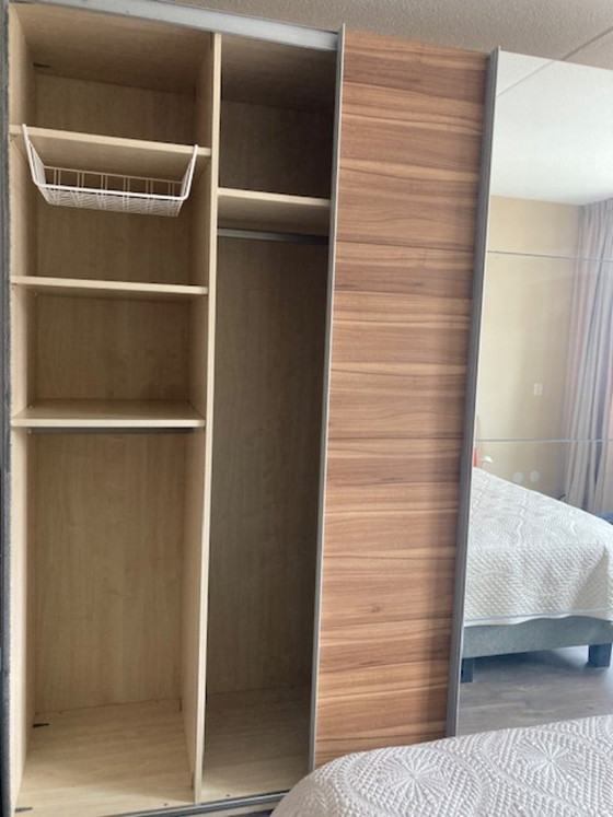 Image 1 of Armario moderno IKEA PAX que va desde el suelo hasta el techo, con puertas correderas de cierre suave.