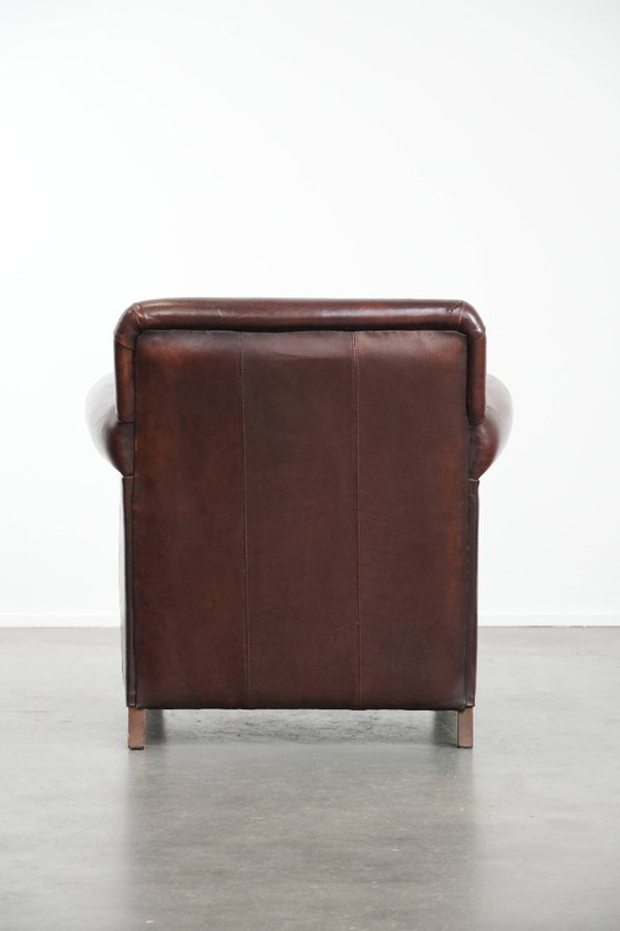 Image 1 of Fauteuil en peau de mouton aux couleurs chaudes et à la finition classique orné de clous décoratifs