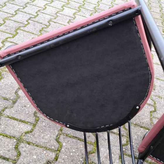 Image 1 of This is a set of four vintage 'Memphis' style chairs with a black metal frame and burgundy upholstery.