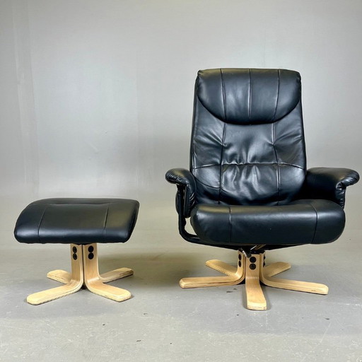 Two‑piece lounge set by Ekornes comprising a swivel reclining armchair and a matching footstool in black leather with a wood fra