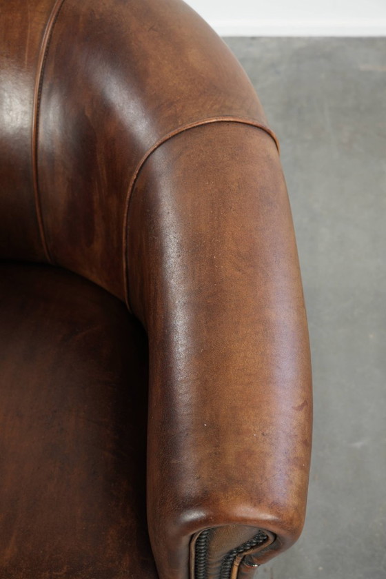 Sturdy and characterful sheepskin club armchair with a beautiful patina, finished with decorative nails. (photo 8 of 12)