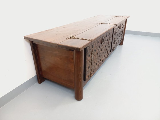 Image 1 of Een laag, brutalistisch dressoir van Georges Robert, gemaakt van donker grenenhout, uit de jaren 50/60.