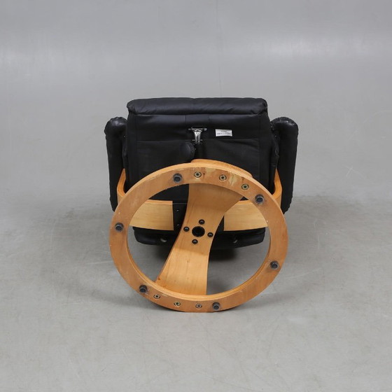 Image 1 of Sweden-origin Scandinavian lounge armchair with a matching ottoman, featuring a black leather and wood frame, in good condition 