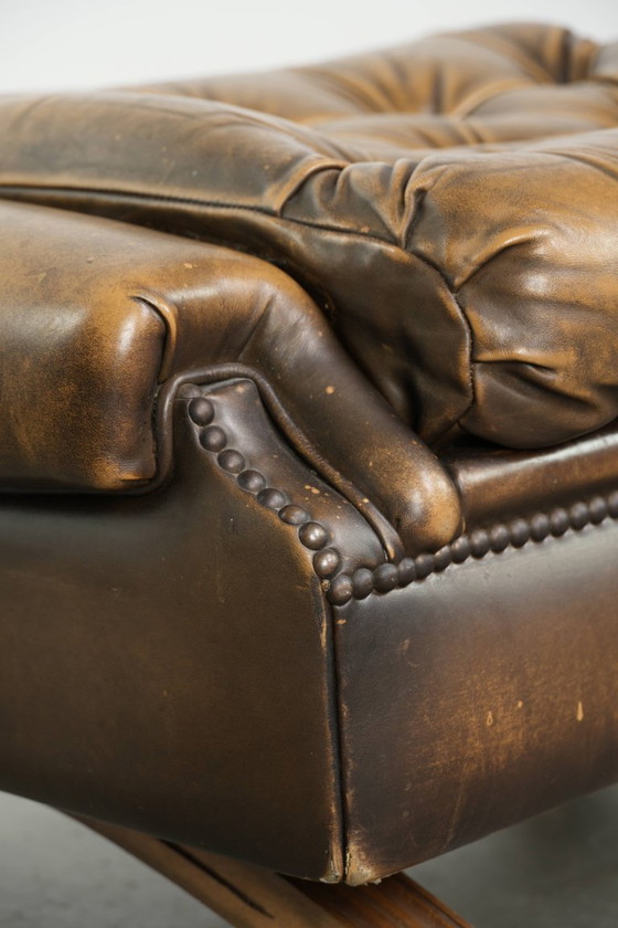 Image 1 of Exclusivo y elegante puf inglés Chesterfield de piel de vacuno con ruedas y acabado con clavos decorativos.