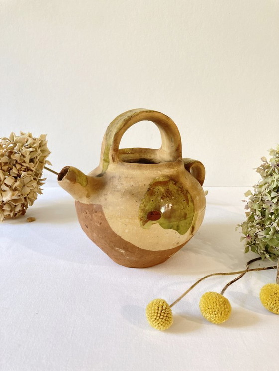 Image 1 of Klein Provençaals kannetje in de vorm van een geit, gemaakt van crèmewit en lichtgroen geglazuurd aardewerk.