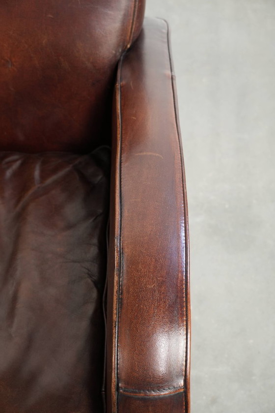 Image 1 of 2x dunkel cognacfarbene Schaffellsessel mit abgerundeten Formen und elegantem Design