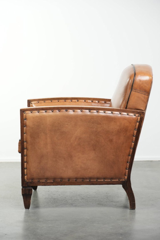 Image 1 of Schapenleren art Deco fauteuil met mooi houtsnijwerk en zwarte biezen