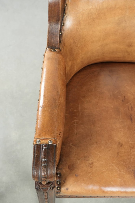 Image 1 of Antique armchair of sheepskin and wood with decorative nails and beautiful woodwork