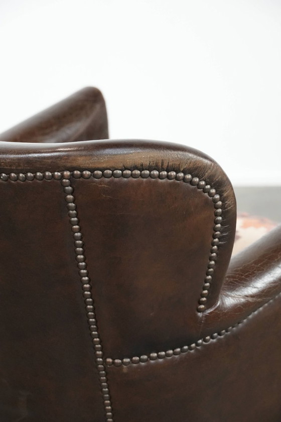 Image 1 of Subtiele donkerbruine fauteuil gemaakt van rundleer met een omkeerbaar Kelim zitkussen