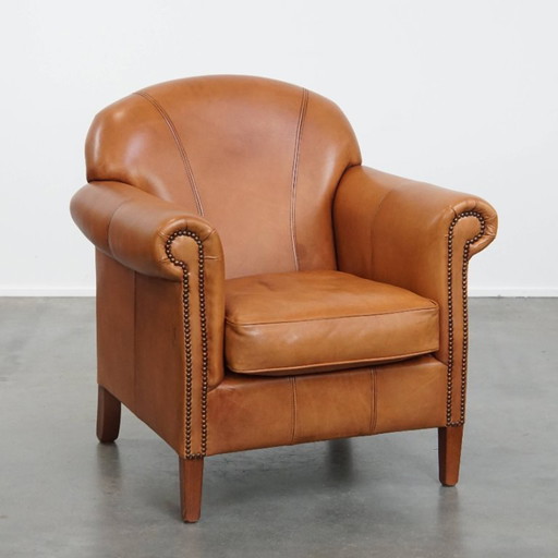 Rundleren fauteuil/ armchair in cognac kleur afgewerkt met siernagels