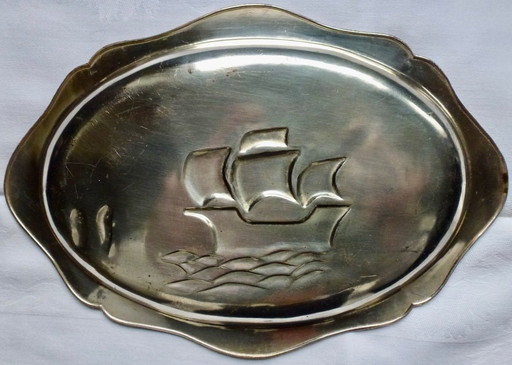 Ciotola decorativa placcata in argento con rappresentazione in rilievo dettagliata.