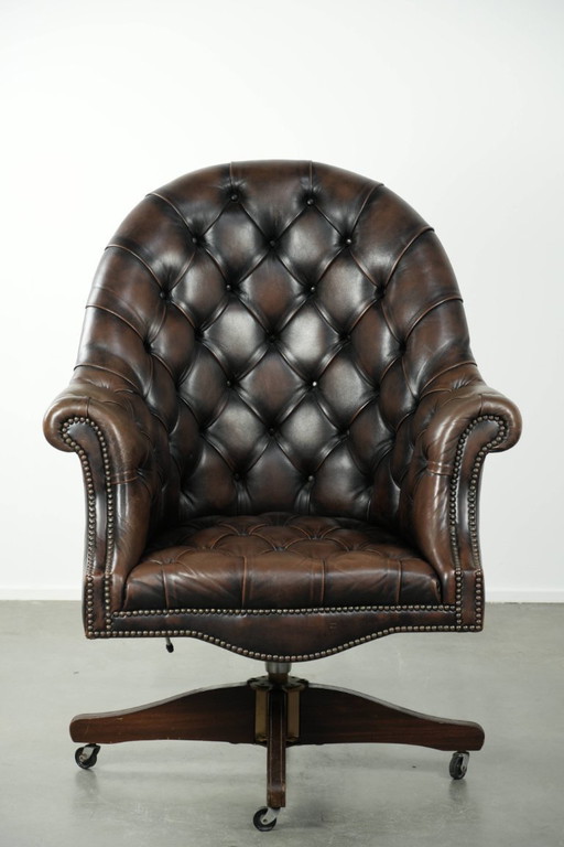 Grote bruine rundleren vintage chesterfield bureaustoel in hoogte verstelbaar en draaibaar op wieltjes met siernagels 