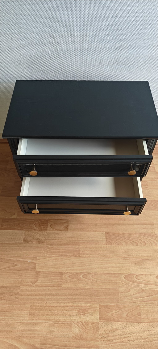 schwarze Kommoden mit goldenen Knöpfen