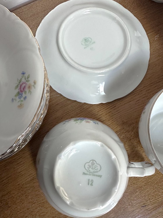 Image 1 of 11 tazze e 9 piattini vintage in porcellana bianca con decorazioni floreali, risalenti al XX secolo e numerati.