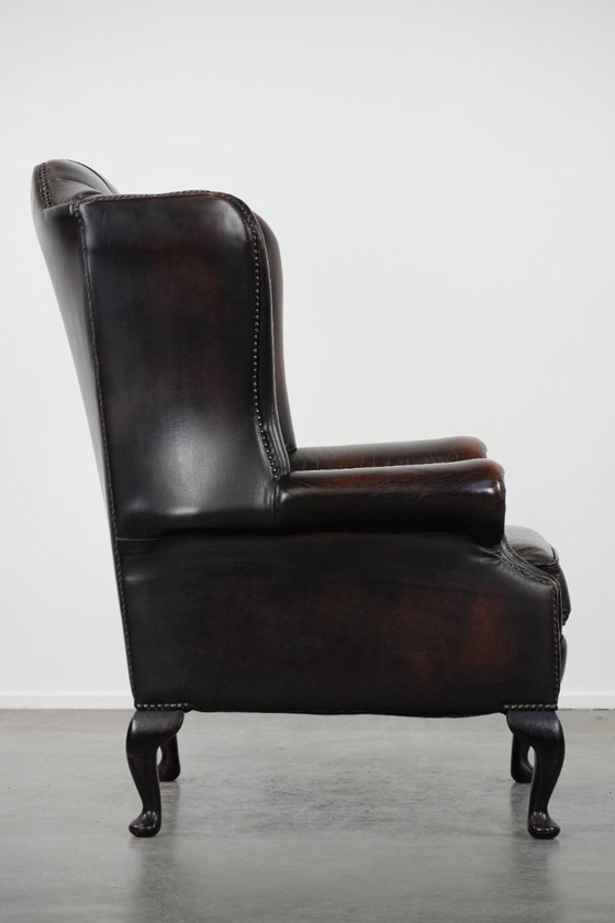 Image 1 of Poltrona Chesterfield con braccioli in pelle bovina marrone, in classico stile inglese.
