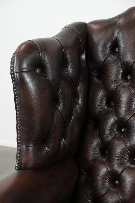 Image 1 of Tijdloze bruine rundleren chesterfield oorfauteuil in Engelse stijl