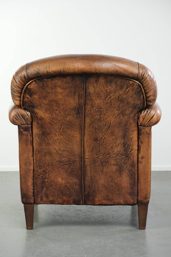 Comoda poltrona in pelle di pecora, dal carattere deciso, rifinita con borchie decorative e una splendida (photo 4 of 13)