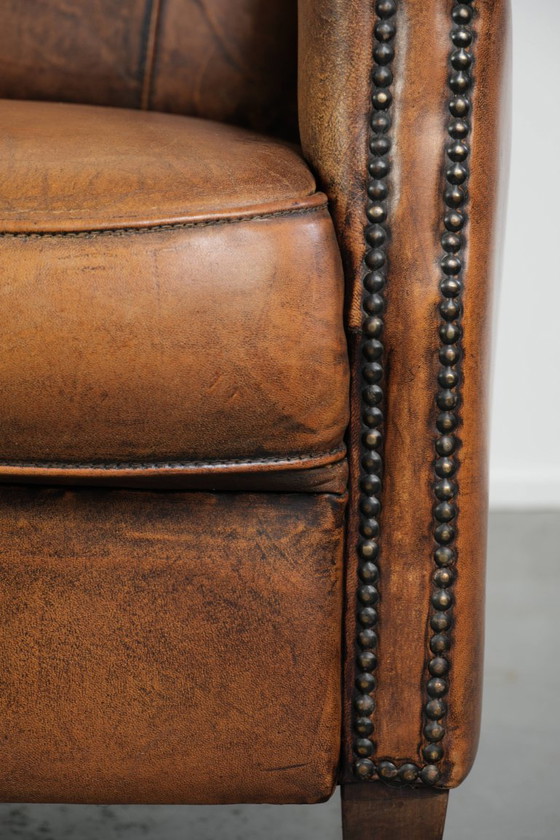 Comoda poltrona in pelle di pecora, dal carattere deciso, rifinita con borchie decorative e una splendida (photo 12 of 13)
