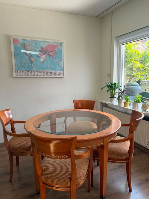 round wooden dining table with glass top and 4 matching chairs
