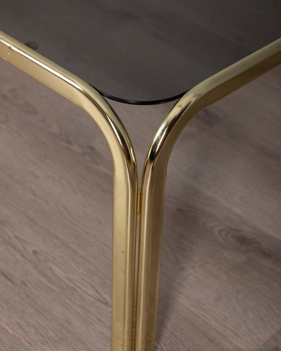 Image 1 of Vintage salontafel uit de jaren 70 in Italiaans design, uitgevoerd in verguld messing en rookglas.
