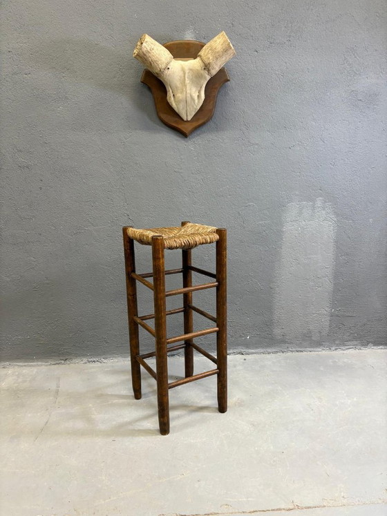 Image 1 of Vintage barkruk in rustieke stijl met massief houten zitting van riet.