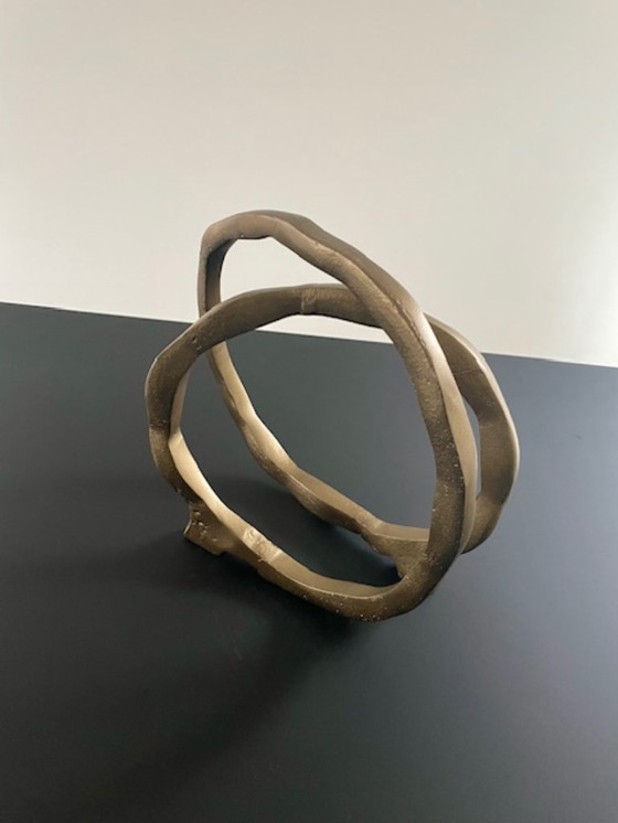 Image 1 of Escultura de diseño con forma de anillo abierto en oro mate.