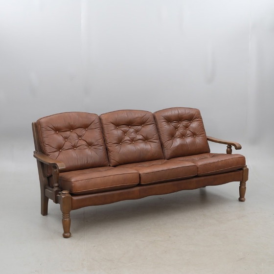 Image 1 of A vintage brown three-piece sofa set in leather with wooden armrests and turned legs, comprising a 1-seater, 2-seater and 3-seat