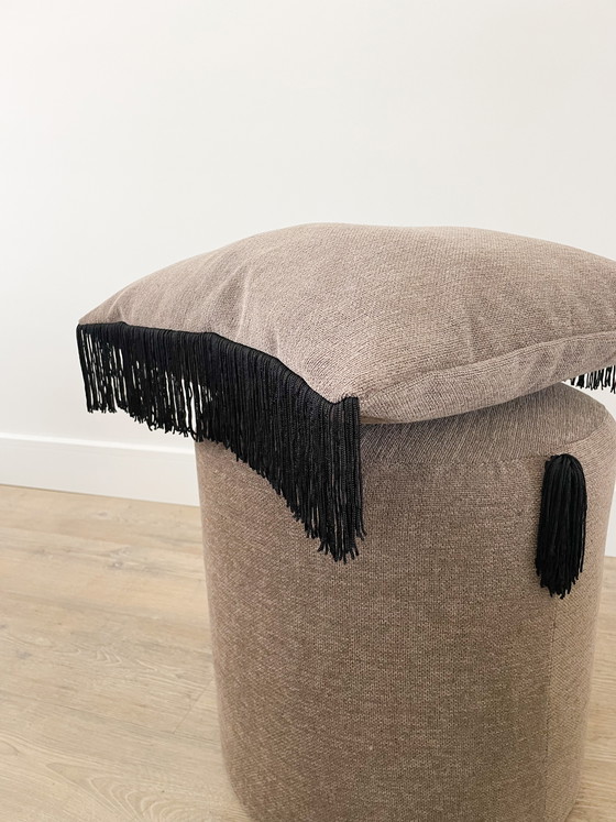 Image 1 of Pouf fatto a mano con dettagli a frange nere.