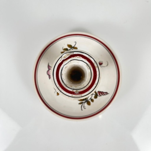 Handbeschilderde keramische kaarsenhouder met bloemenmotief.