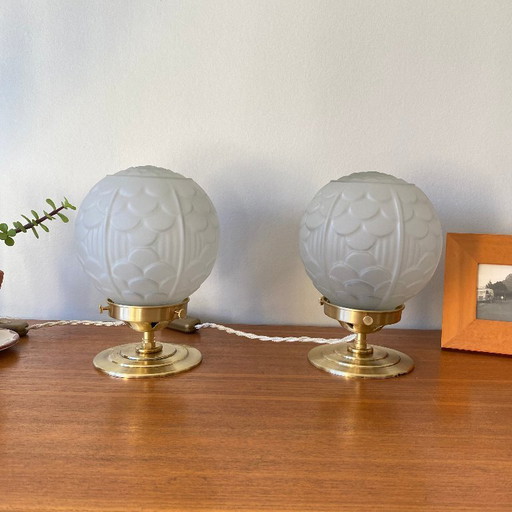 Pair of vintage bedside lamps with antique glass globes and brass bases, circa 1950