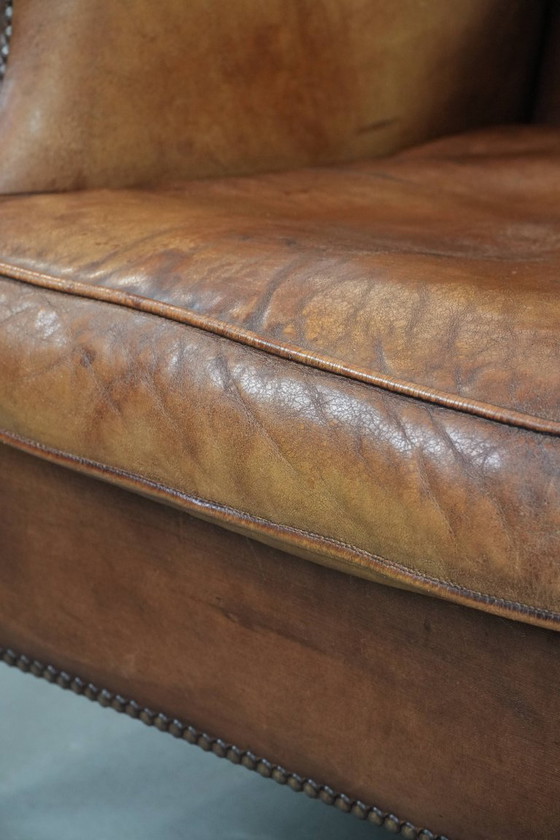 Image 1 of Sillón orejero de piel de oveja acabado con clavos decorativos