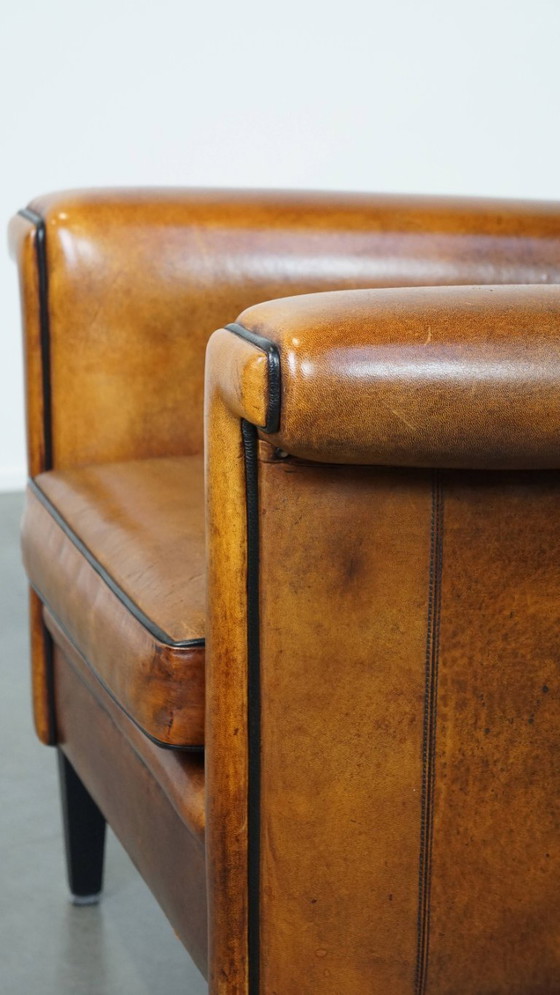 Image 1 of Sillón de diseño Art Déco en buen estado, con un acabado elegante y ribetes negros.