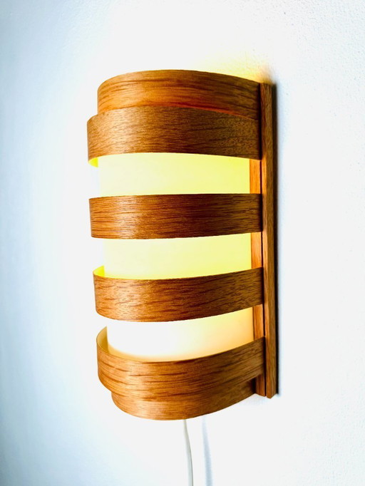 Elegant mid-century wall lamp crafted from curved pine veneer, produced in Sweden during the 1960s.
