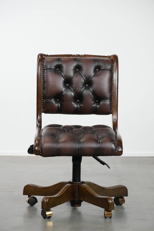 Fauteuil de bureau Chesterfield de style anglais, en cuir de vachette et bois, sur roulettes.