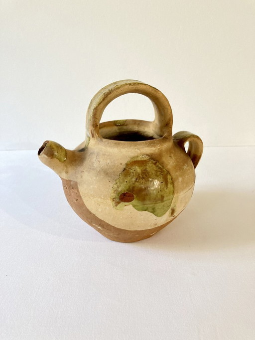 Kleiner provenzalischer Krug in Ziegenform aus cremeweißem und hellgrünem glasiertem Steinzeug.